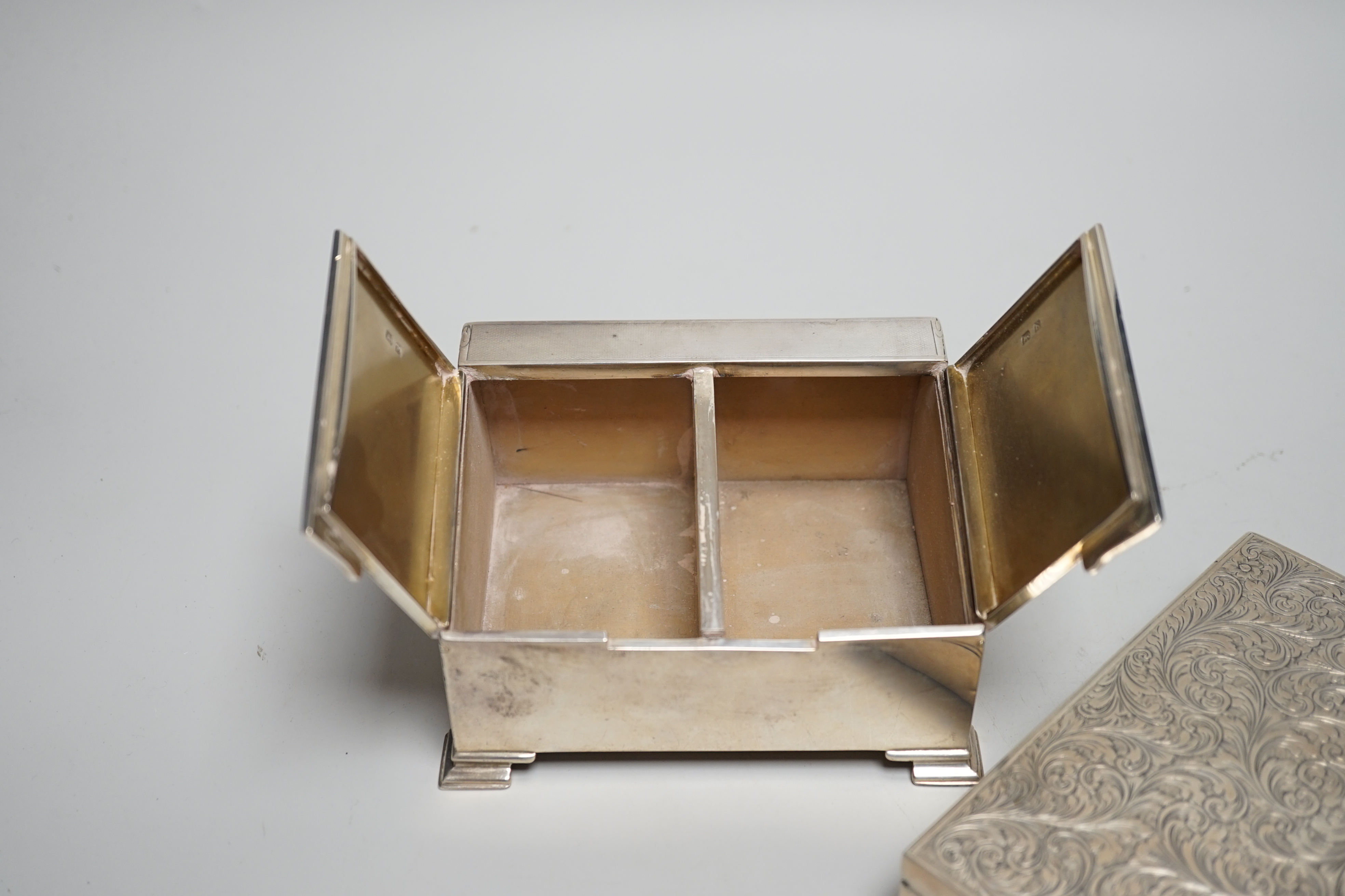 A George V Art Deco engine turned silver twin compartment cigarette box, with slant front, W.I. Broadway & Co, Birmingham, 1929, width 12.3cm, together with an engraved 900 white metal mounted cigarette box.